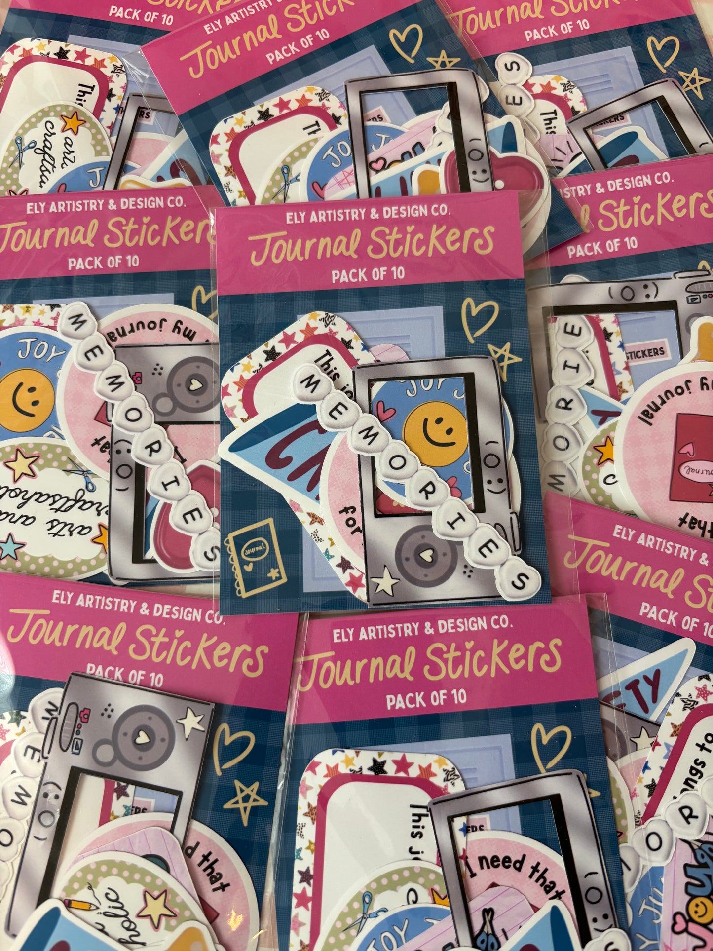 Packets of journal stickers with colorful designs and text, featuring the brand 'Ely Artistik & Design Co'.