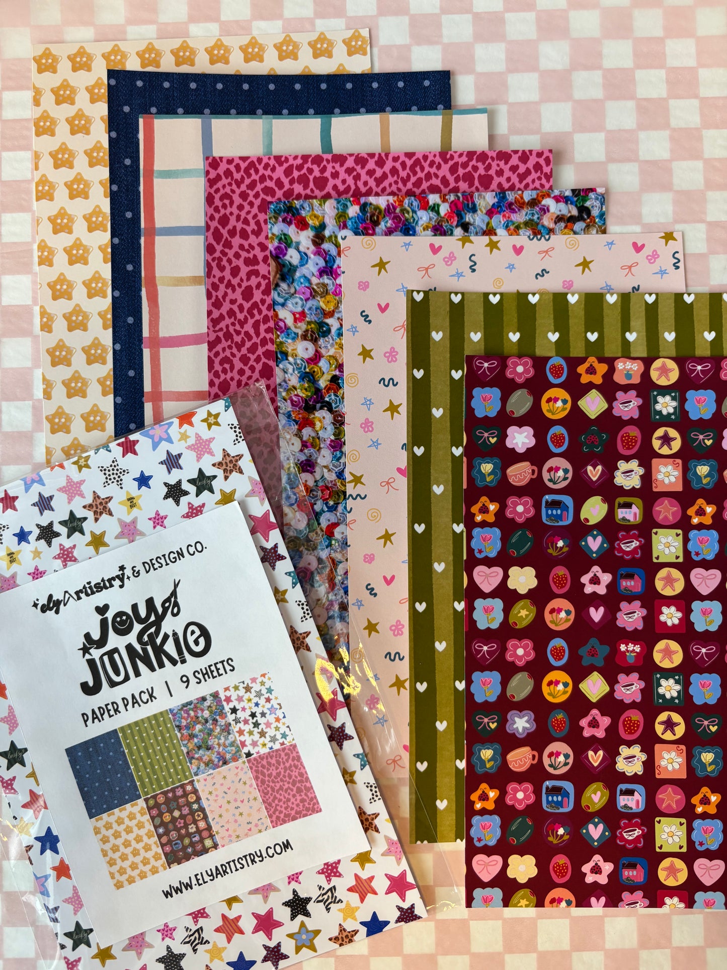 Collection of colorful patterned paper sheets on a checkered background